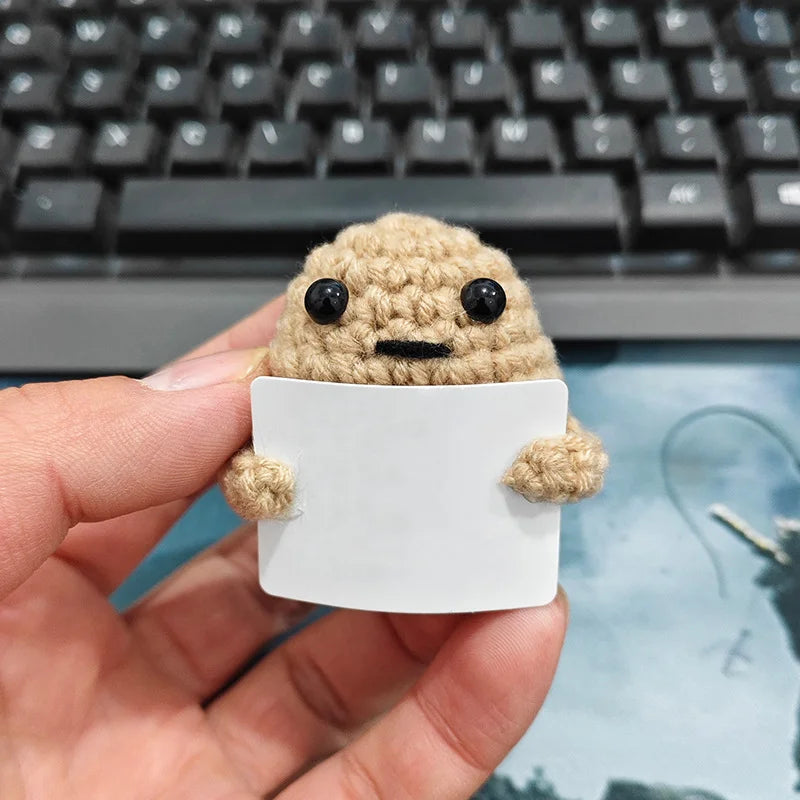 Khaki Small design: small khaki crochet potato doll held in a hand, with a blank card
