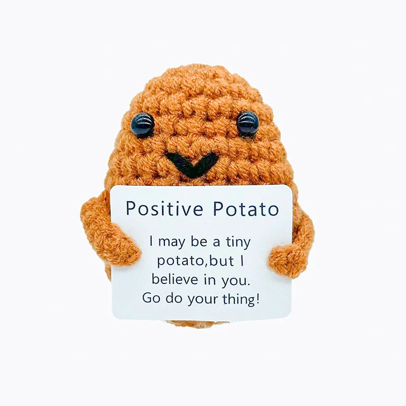 Caramel Little design: small caramel-coloured crochet potato doll holding a small card